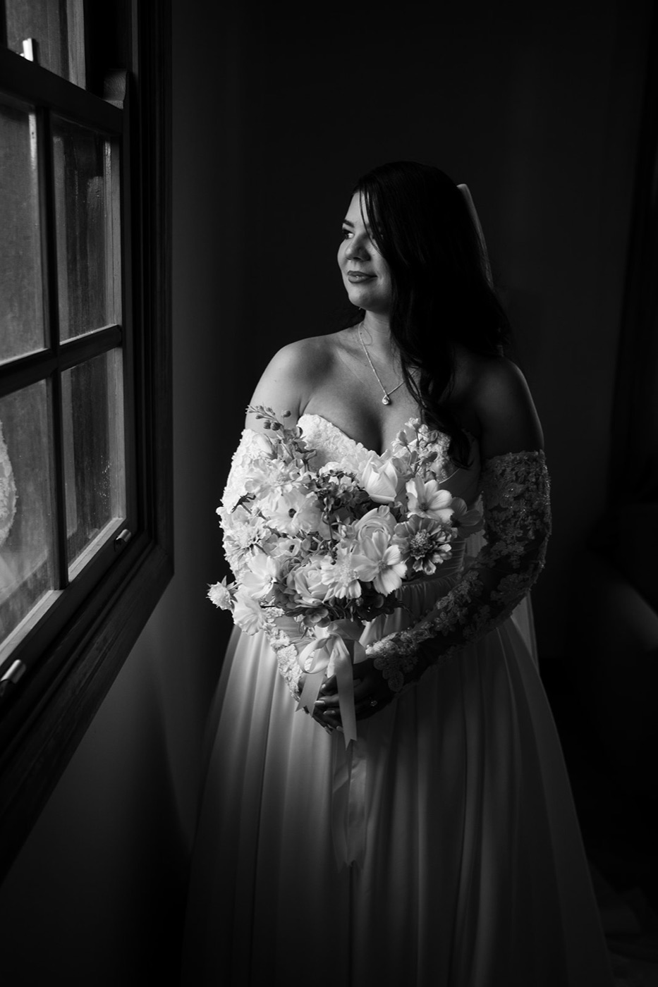 Bride by a dark window, black and white