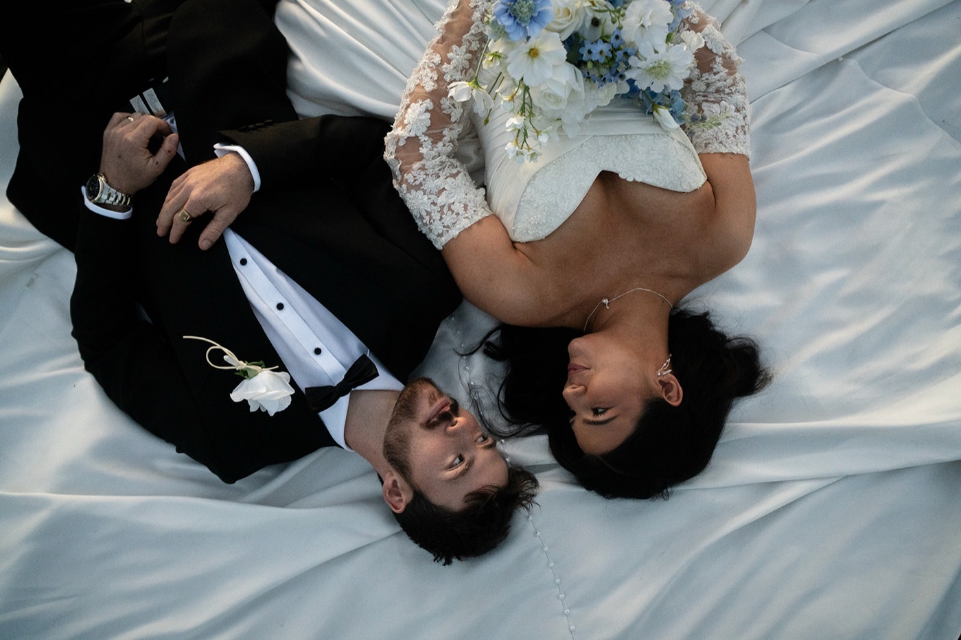 Couple lying on the wedding dress, from above