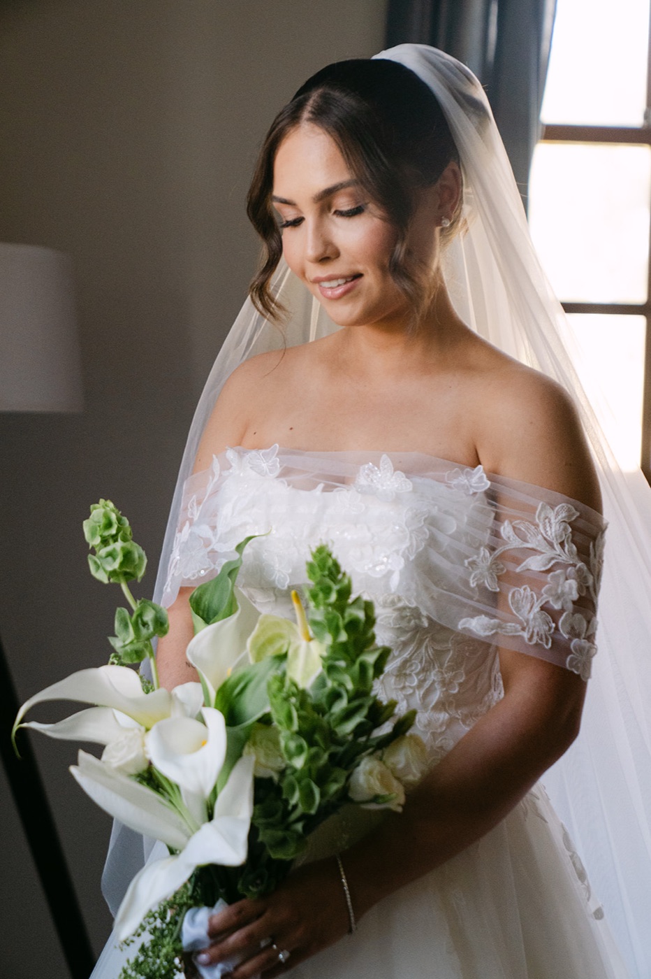 Bride in window light with lilies